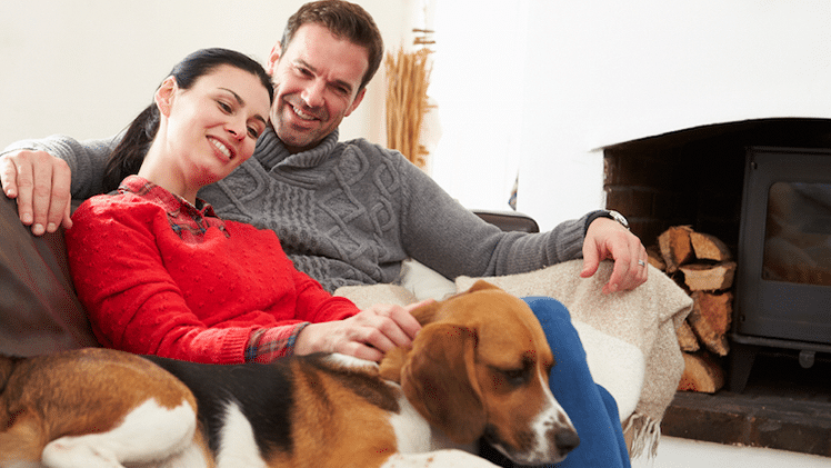 Couple sitting on their couch with a dog