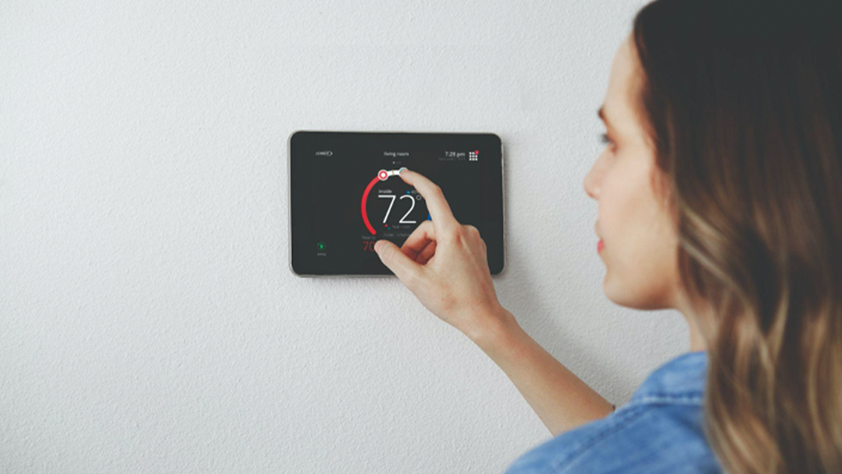 Woman adjust a thermostat