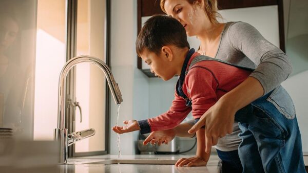 Mother and son using sink